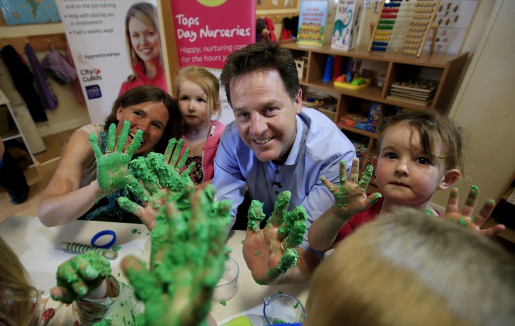 Liberal Democrat leader Nick Clegg along with parliamentary candidate Vikke Sladi (left) make play dough with Abi Round (second left) and Grace Lewis (right) as he visits Tops Day Nursery, Corfe Mullen in Dorset while on the General Election campaign trail.